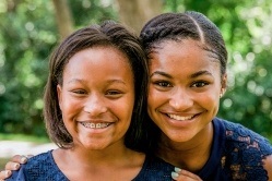 Teen sisters smiling together after orthodontics